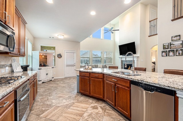 9215 Union Meadow Ln, Cypress, TX 77433 - kitchen featuring stainless steel appliances, arched walkways, brown cabinets, a ceiling fan, and recessed lighting