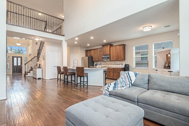 9215 Union Meadow Ln, Cypress, TX 77433 - living area featuring dark wood-style flooring, stairs, a towering ceiling, and recessed lighting