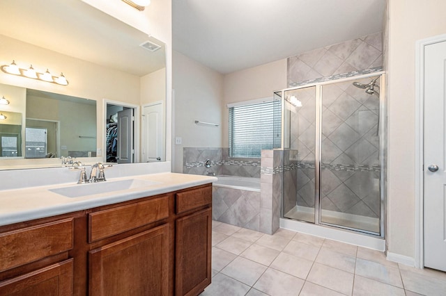 9215 Union Meadow Ln, Cypress, TX 77433 - bathroom featuring tile patterned floors, a garden tub, a walk in closet, vanity, and a shower stall