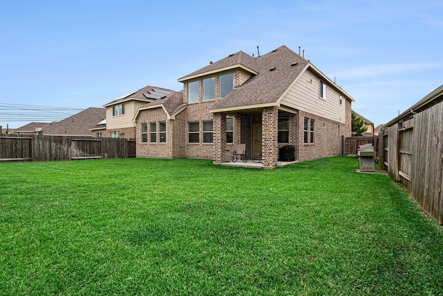 9215 Union Meadow Ln, Cypress, TX 77433 - back of house with brick siding, a fenced backyard, roof with shingles, and a patio