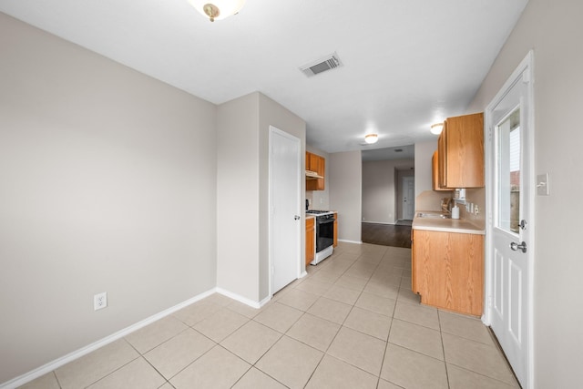 14239 Brunswick Point Ln, Houston, TX 77047 - kitchen featuring gas range gas stove, light countertops, and light tile patterned flooring