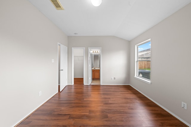 14239 Brunswick Point Ln, Houston, TX 77047 - unfurnished bedroom featuring a spacious closet, lofted ceiling, and dark wood-type flooring