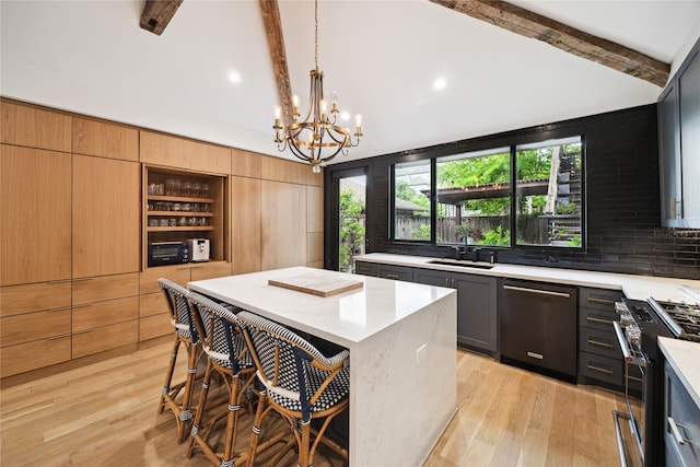 406 Bomar St, Houston, TX 77006 - kitchen with stainless steel gas range, dishwashing machine, a chandelier, a breakfast bar, and light wood finished floors