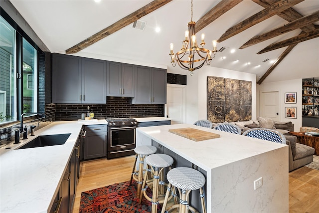 406 Bomar St, Houston, TX 77006 - kitchen with gas range, beam ceiling, light stone countertops, backsplash, and a center island