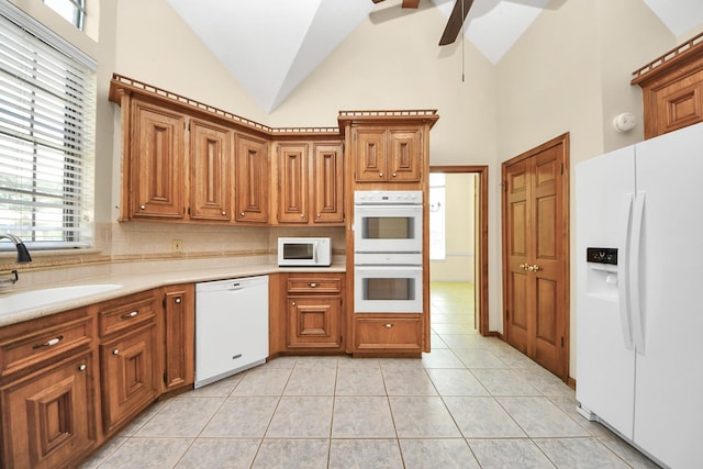 10503 Great Plains Ln, Houston, TX 77064 - kitchen with white appliances, a ceiling fan, backsplash, high vaulted ceiling, and light countertops