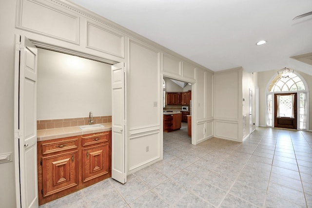 10503 Great Plains Ln, Houston, TX 77064 - kitchen featuring a decorative wall, light tile patterned floors, tile counters, decorative backsplash, and recessed lighting