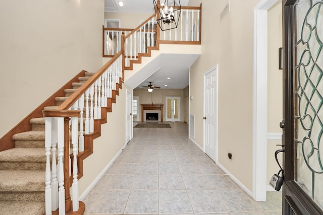 10503 Great Plains Ln, Houston, TX 77064 - entryway with stairs, light tile patterned floors, ceiling fan, a towering ceiling, and a fireplace with raised hearth