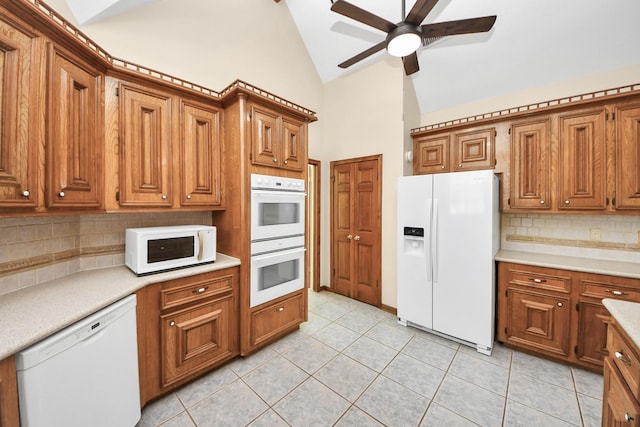 10503 Great Plains Ln, Houston, TX 77064 - kitchen featuring white appliances, ceiling fan, high vaulted ceiling, brown cabinetry, and decorative backsplash