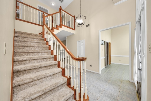 10503 Great Plains Ln, Houston, TX 77064 - staircase with a high ceiling, tile patterned floors, and a chandelier