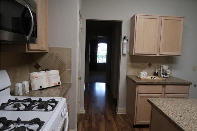 1714 Oak Ridge Dr, Kemah, TX 77565 - kitchen featuring stainless steel microwave, white gas range oven, light brown cabinets, dark wood finished floors, and tasteful backsplash