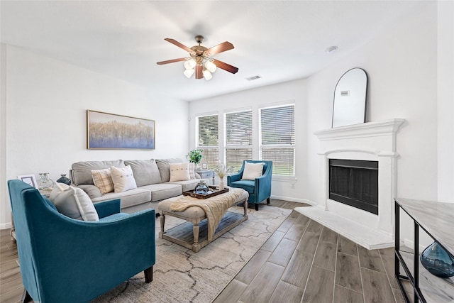 31 Hearthwick Rd, Tomball, TX 77375 - living area featuring a ceiling fan, wood finished floors, and a fireplace with raised hearth
