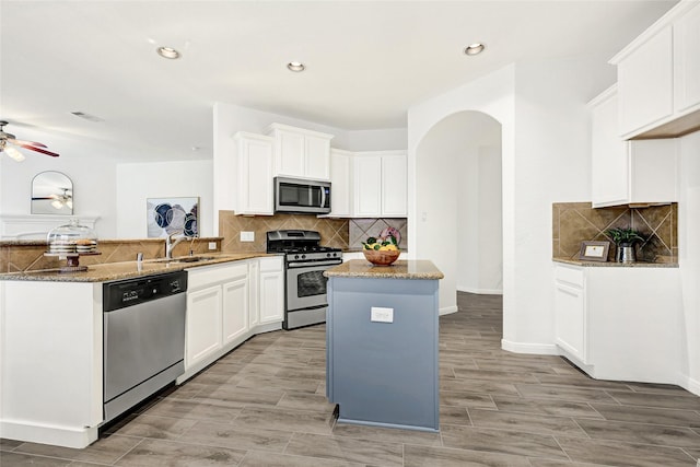 31 Hearthwick Rd, Tomball, TX 77375 - kitchen with appliances with stainless steel finishes, a peninsula, light stone counters, tasteful backsplash, and recessed lighting