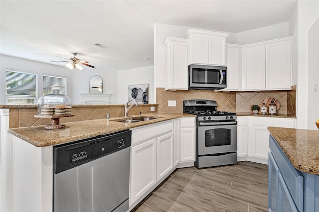 31 Hearthwick Rd, Tomball, TX 77375 - kitchen with appliances with stainless steel finishes, a peninsula, ceiling fan, decorative backsplash, and white cabinets