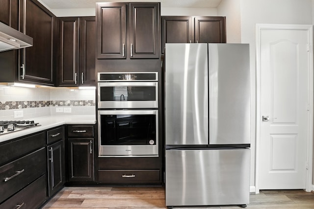 8618 Cedar Plains Ln, Houston, TX 77080 - kitchen with appliances with stainless steel finishes, extractor fan, light wood-style flooring, and tasteful backsplash