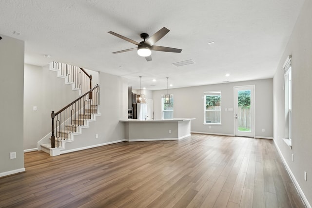 8618 Cedar Plains Ln, Houston, TX 77080 - unfurnished living room featuring a ceiling fan, wood finished floors, stairway, and recessed lighting