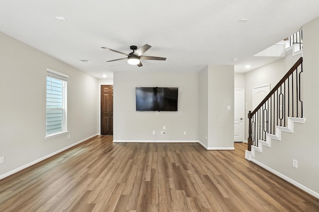 8618 Cedar Plains Ln, Houston, TX 77080 - unfurnished living room featuring wood finished floors, ceiling fan, stairway, and recessed lighting