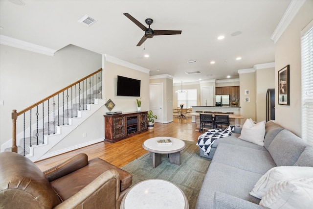 1219 Hickory St, Houston, TX 77007 - living area featuring crown molding, light wood-style floors, ceiling fan, recessed lighting, and stairway