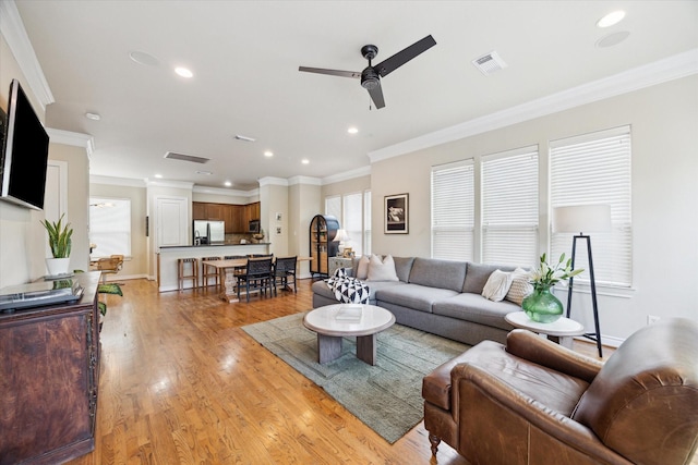 1219 Hickory St, Houston, TX 77007 - living room featuring a ceiling fan, crown molding, light wood-style floors, and recessed lighting