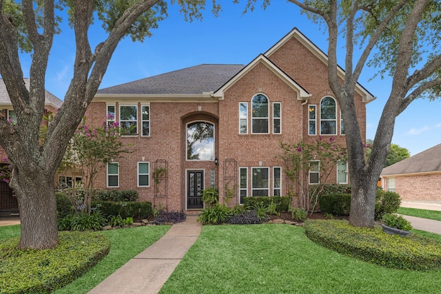 8639 Ballinger Dr, Houston, TX 77064 - traditional home featuring a front yard, brick siding, and french doors
