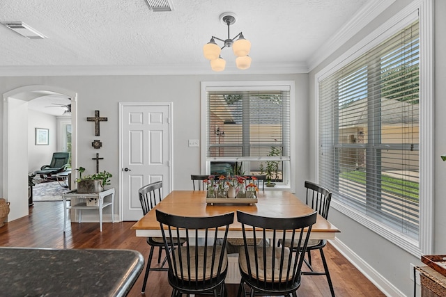 8639 Ballinger Dr, Houston, TX 77064 - dining room with dark wood-style floors, arched walkways, ornamental molding, a ceiling fan, and a chandelier