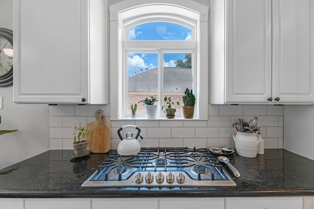 8639 Ballinger Dr, Houston, TX 77064 - kitchen with stainless steel gas stovetop, white cabinets, tasteful backsplash, and dark stone countertops