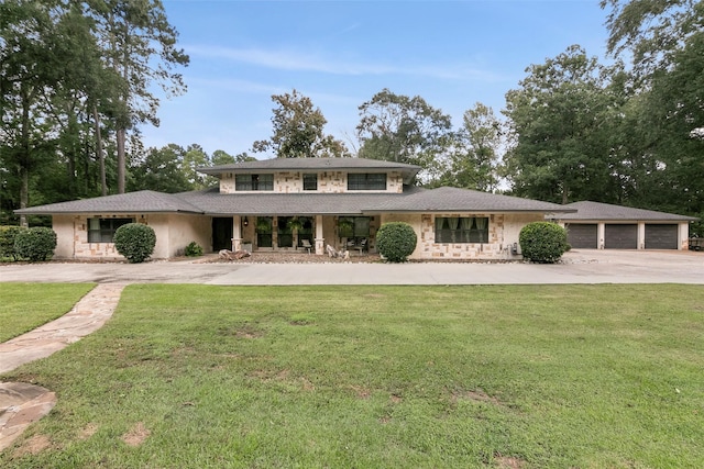 1025 Creek Bnd, Jasper, TX 75951 - view of front facade featuring stone siding, a front lawn, driveway, and covered porch