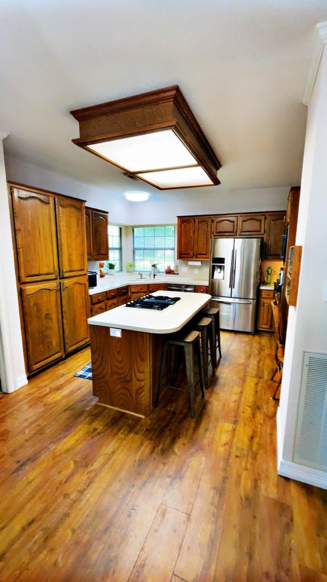 1600 Azalea St, Sweeny, TX 77480 - kitchen with stainless steel fridge, light countertops, a kitchen island, gas stovetop, and light wood-type flooring