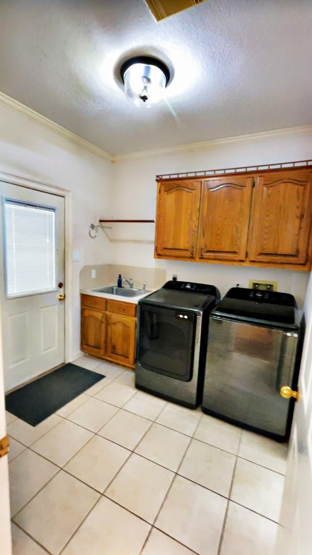 1600 Azalea St, Sweeny, TX 77480 - laundry room featuring cabinet space, crown molding, washing machine and dryer, light tile patterned floors, and a textured ceiling