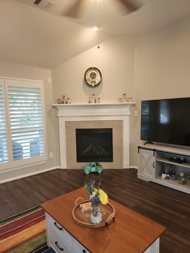 3514 Tulip Trace Dr, Spring, TX 77386 - living room featuring dark wood-type flooring, a tiled fireplace, a ceiling fan, and vaulted ceiling