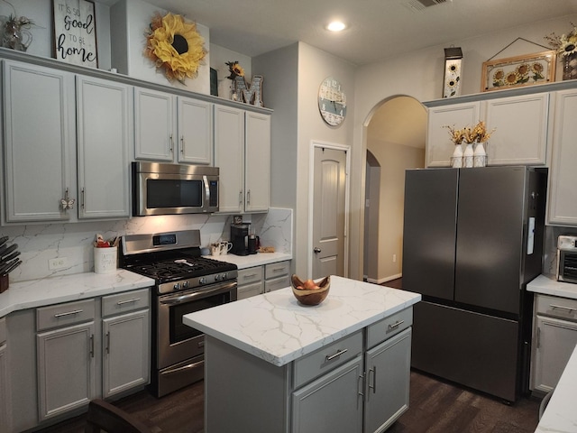 3514 Tulip Trace Dr, Spring, TX 77386 - kitchen featuring appliances with stainless steel finishes, gray cabinets, arched walkways, dark wood-style floors, and recessed lighting