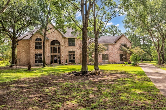 1019 Towering Oaks St, Magnolia, TX 77355 - traditional home with brick siding, a front yard, and a shingled roof
