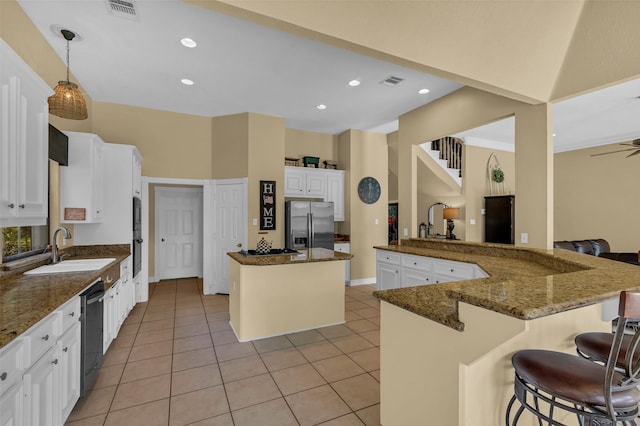 1019 Towering Oaks St, Magnolia, TX 77355 - kitchen featuring appliances with stainless steel finishes, a center island, light tile patterned floors, dark stone countertops, and recessed lighting