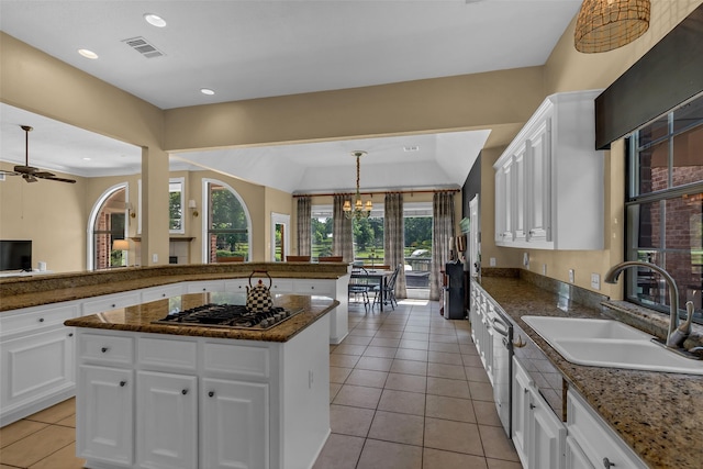 1019 Towering Oaks St, Magnolia, TX 77355 - kitchen featuring stainless steel appliances, light tile patterned floors, white cabinets, a center island, and dark stone counters