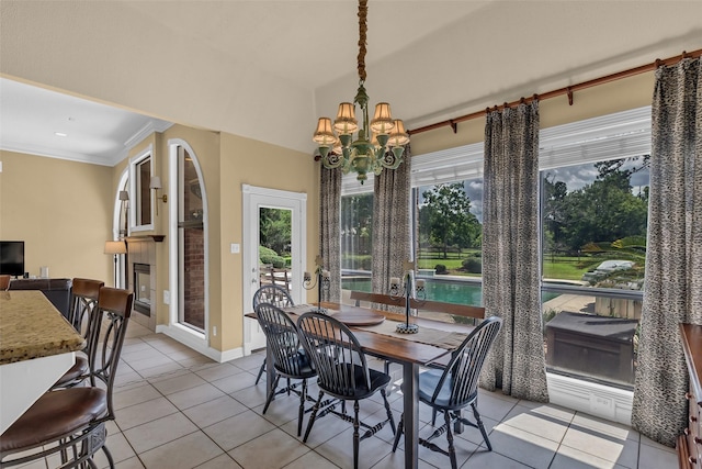 1019 Towering Oaks St, Magnolia, TX 77355 - dining space with light tile patterned flooring, a chandelier, a glass covered fireplace, and ornamental molding