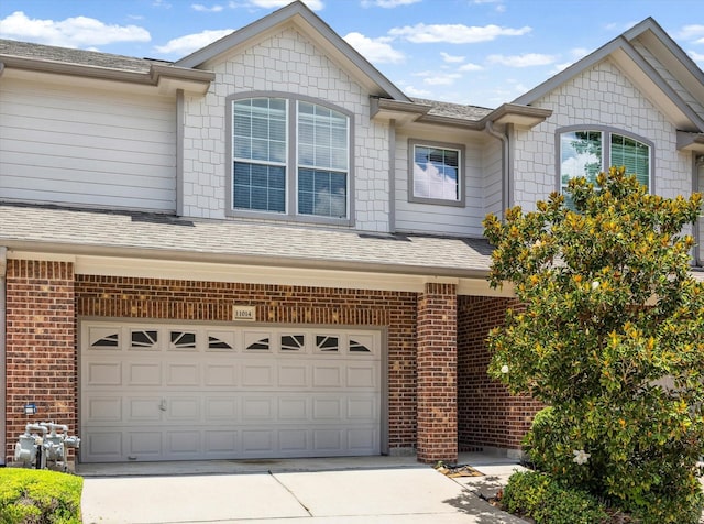 11014 Bakerwood Dr, Houston, TX 77064 - view of front of home with an attached garage, concrete driveway, brick siding, and roof with shingles