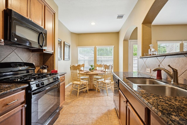 11014 Bakerwood Dr, Houston, TX 77064 - kitchen featuring black appliances, decorative backsplash, brown cabinetry, arched walkways, and recessed lighting