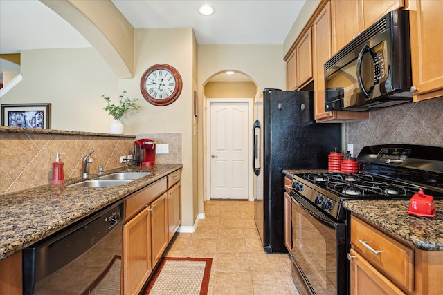 11014 Bakerwood Dr, Houston, TX 77064 - kitchen featuring black appliances, arched walkways, tasteful backsplash, dark stone countertops, and light tile patterned floors