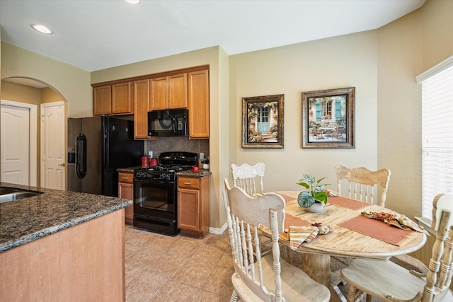 11014 Bakerwood Dr, Houston, TX 77064 - kitchen featuring black appliances, arched walkways, tasteful backsplash, brown cabinets, and recessed lighting