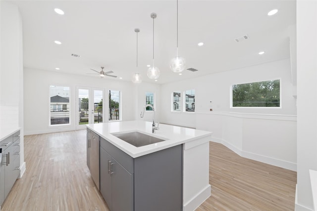 2103 Holman, Houston, TX 77004 - kitchen with gray cabinetry, light countertops, light wood-type flooring, recessed lighting, and hanging light fixtures