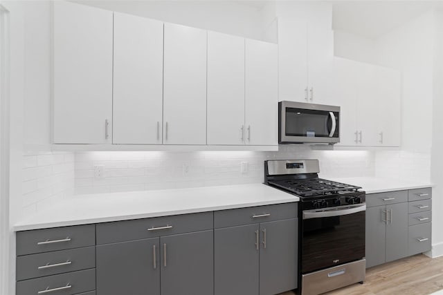 2103 Holman, Houston, TX 77004 - kitchen with appliances with stainless steel finishes, gray cabinetry, light wood-style floors, and light countertops