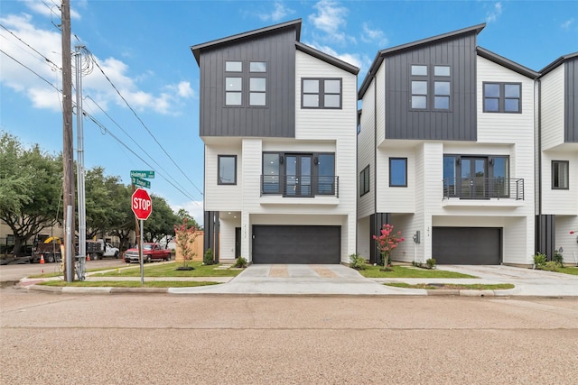2103 Holman, Houston, TX 77004 - view of front facade with board and batten siding, a garage, and driveway