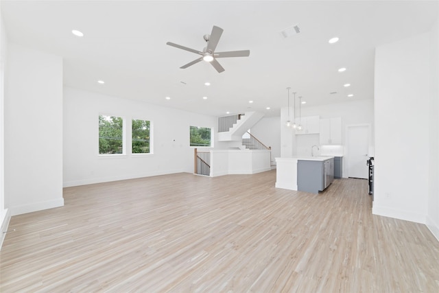 2103 Holman, Houston, TX 77004 - unfurnished living room with a ceiling fan, recessed lighting, light wood-style flooring, and stairway