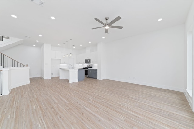 2103 Holman, Houston, TX 77004 - unfurnished living room featuring ceiling fan, stairs, light wood-type flooring, and recessed lighting