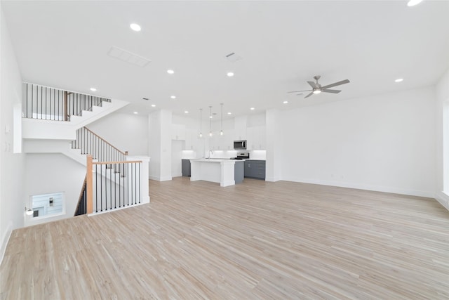 2103 Holman, Houston, TX 77004 - unfurnished living room featuring light wood-type flooring, ceiling fan, recessed lighting, and stairway
