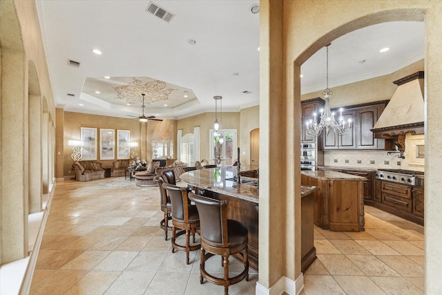 15611 Oyster Cove Dr, Sugar Land, TX 77478 - kitchen featuring arched walkways, appliances with stainless steel finishes, custom exhaust hood, open floor plan, and a kitchen breakfast bar