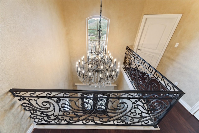 15611 Oyster Cove Dr, Sugar Land, TX 77478 - stairway featuring a chandelier, a high ceiling, a textured wall, and wood finished floors