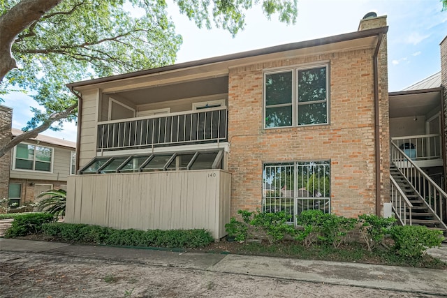 2110 Wilcrest Dr Unit 140, Houston, TX 77042 - view of front facade with a balcony, stairway, and brick siding