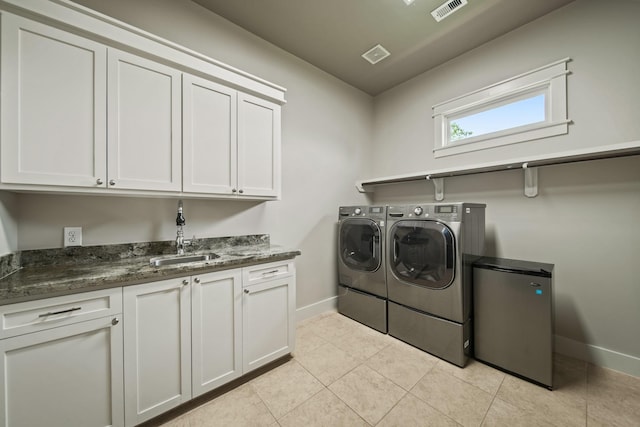 959 W 42nd St, Houston, TX 77018 - washroom with washing machine and dryer, cabinet space, and light tile patterned flooring