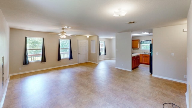 25531 Black St, Splendora, TX 77372 - unfurnished living room with healthy amount of natural light, ceiling fan, and light floors