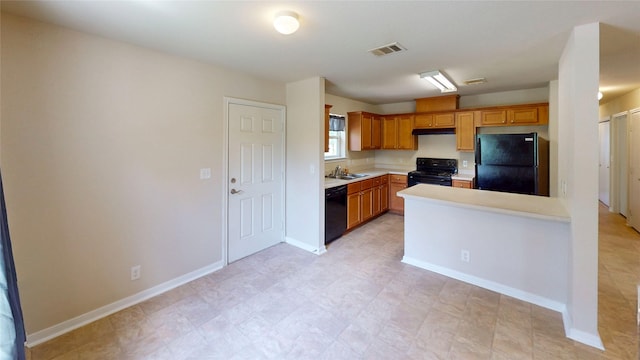 25531 Black St, Splendora, TX 77372 - kitchen with black appliances, light countertops, under cabinet range hood, a peninsula, and brown cabinets